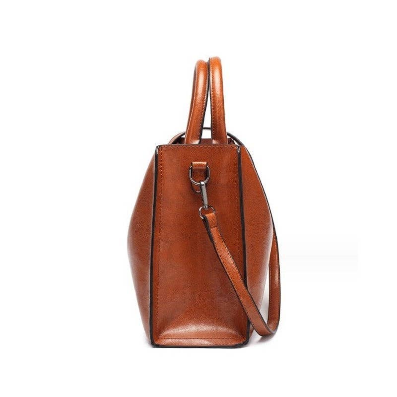 A brown leather handbag with double top handles and a shoulder strap, shown from the side against a plain white background.