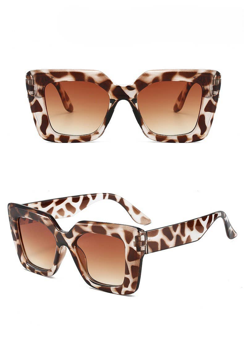 A pair of oversized square sunglasses with a brown, black, and beige leopard print acetate frame and brown gradient lenses, shown from both front and side angles on a white background.
