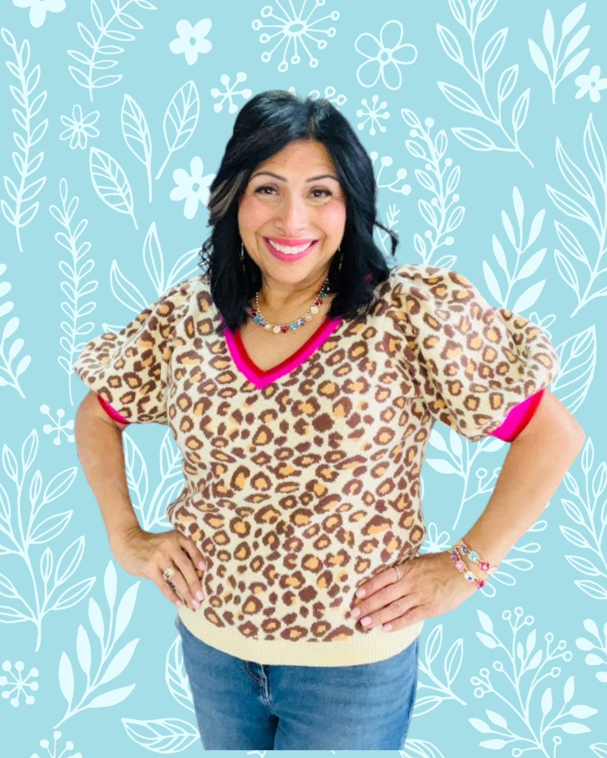Woman wearing a leopard print top with pink trim against a floral patterned background