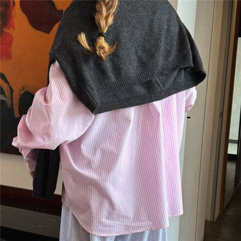 A person shown from the back wearing a light pink and white vertically striped button-up shirt, with a dark charcoal gray knit shrug draped over their shoulders.