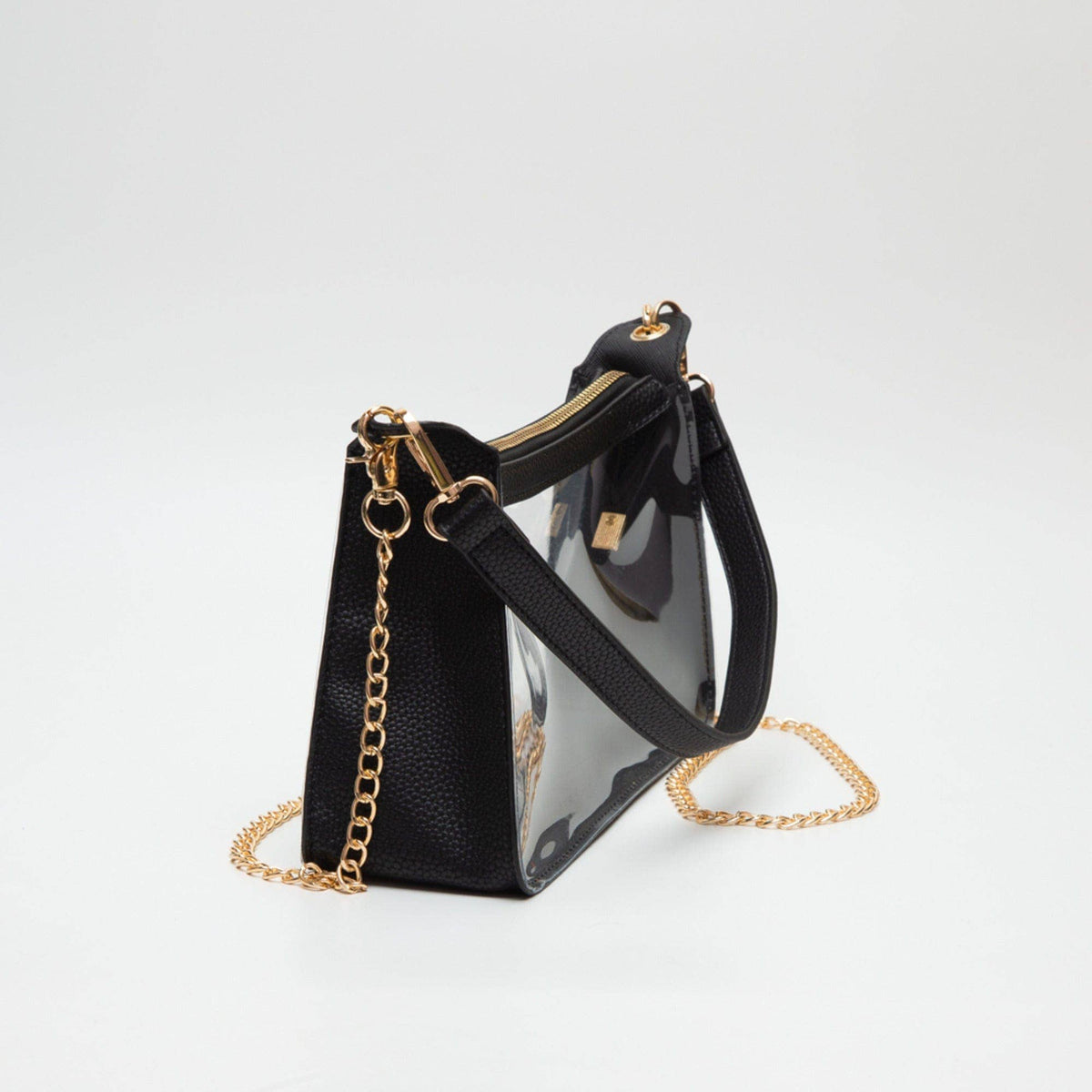 Black handbag with gold chain and clear front panel on a white background