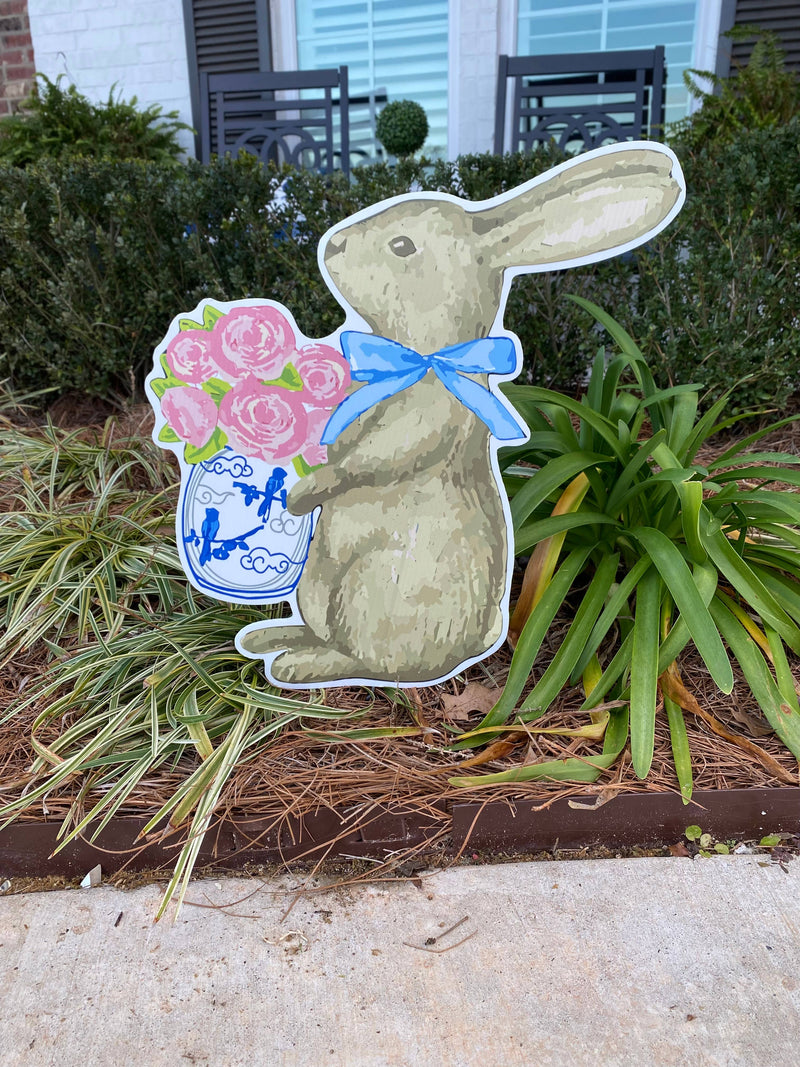 Bunny yard sign holding flowers
