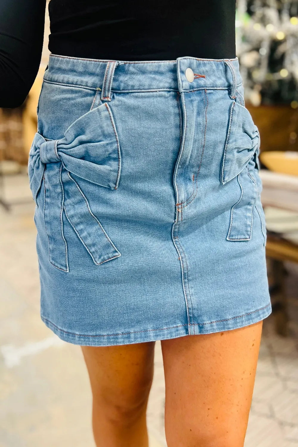 Blue denim skirt worn by a person with a blurred background
