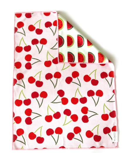 A square white kitchen towel with a red cherry print on the front and a watermelon print on the reverse side, shown on a white background.