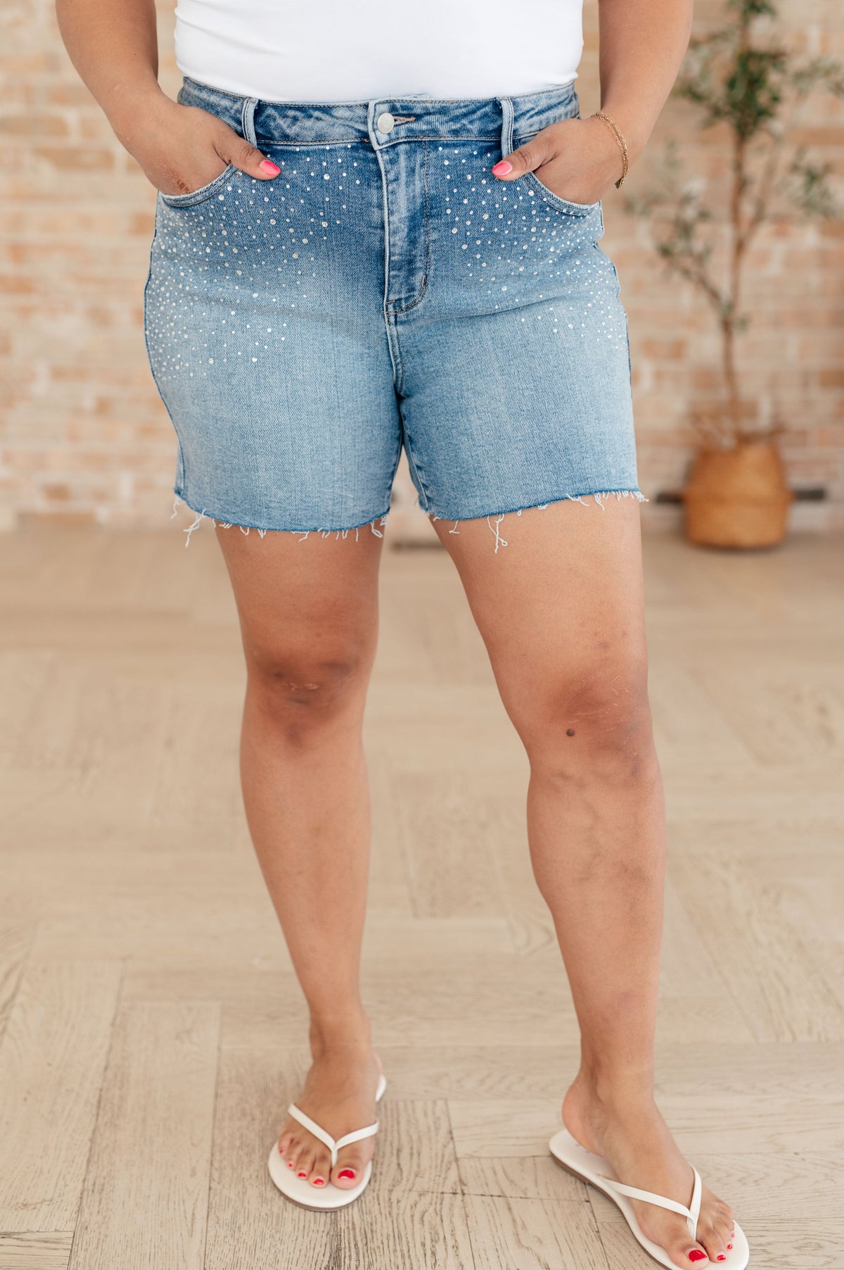 Person wearing light blue denim shorts on a wooden floor.