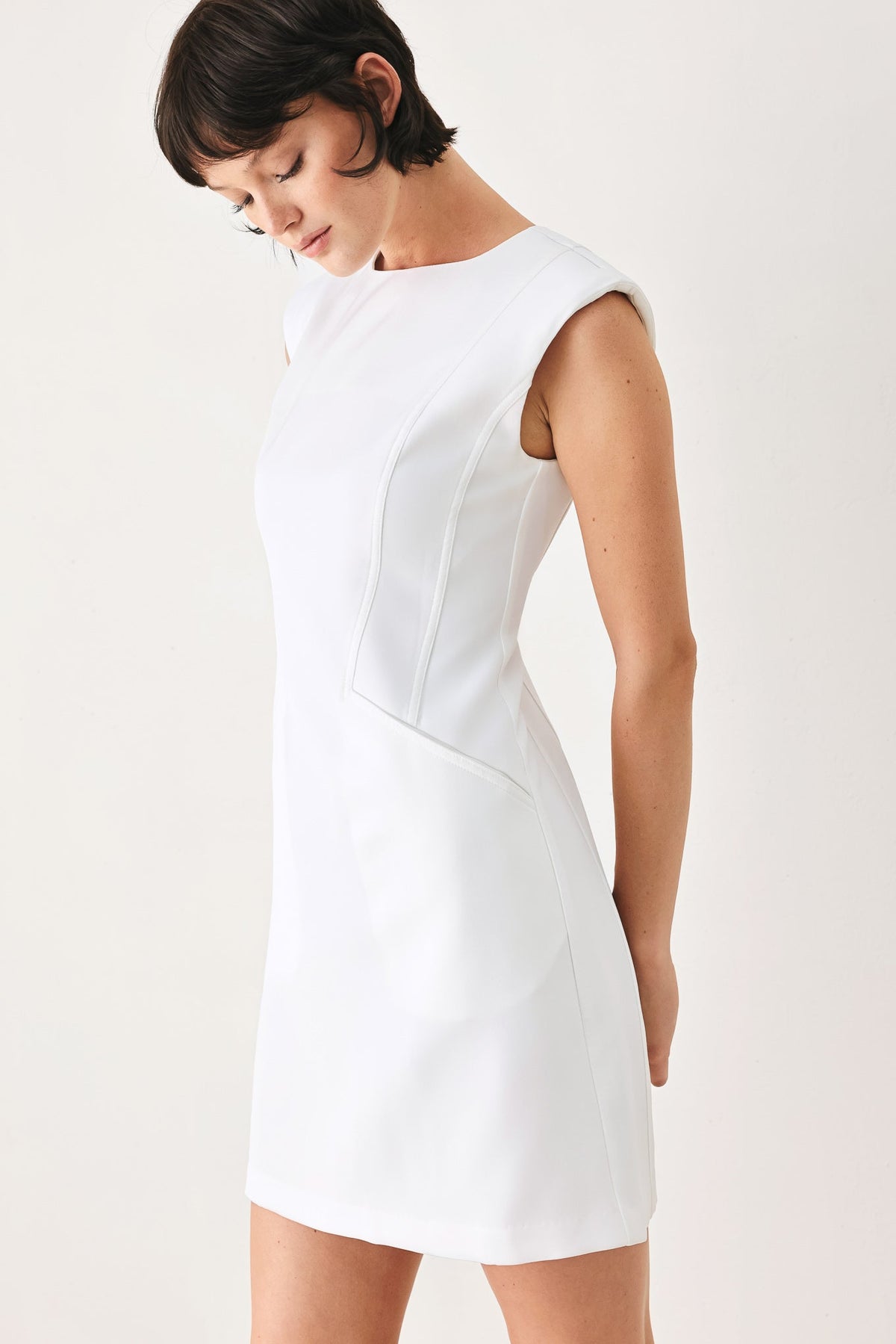 Woman wearing a white dress against a plain background