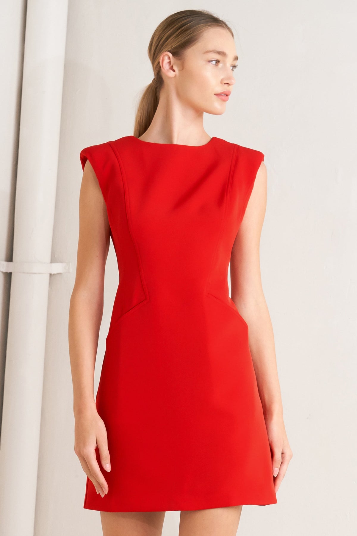 Woman wearing a red dress against a plain background