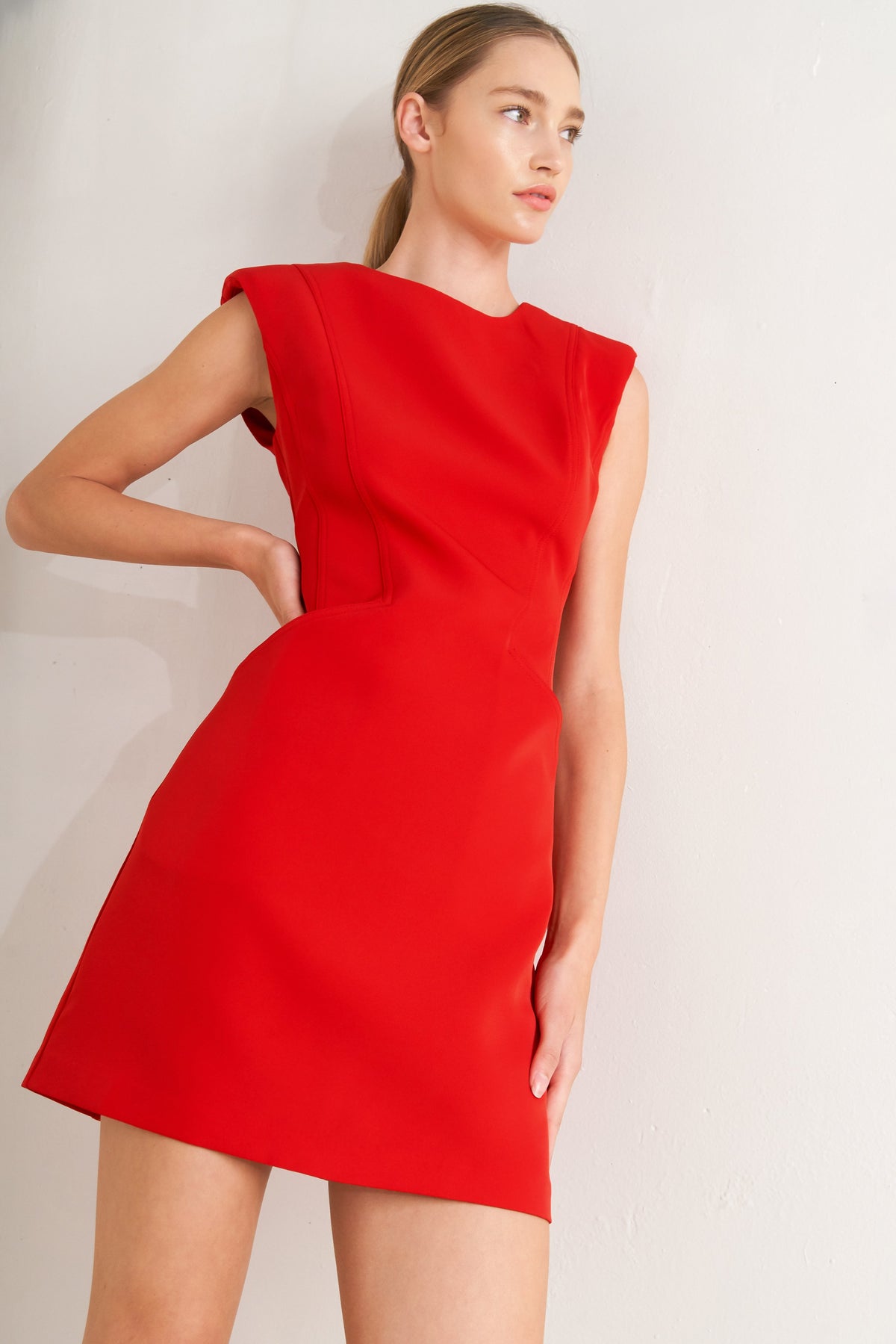 Woman wearing a red dress against a plain background