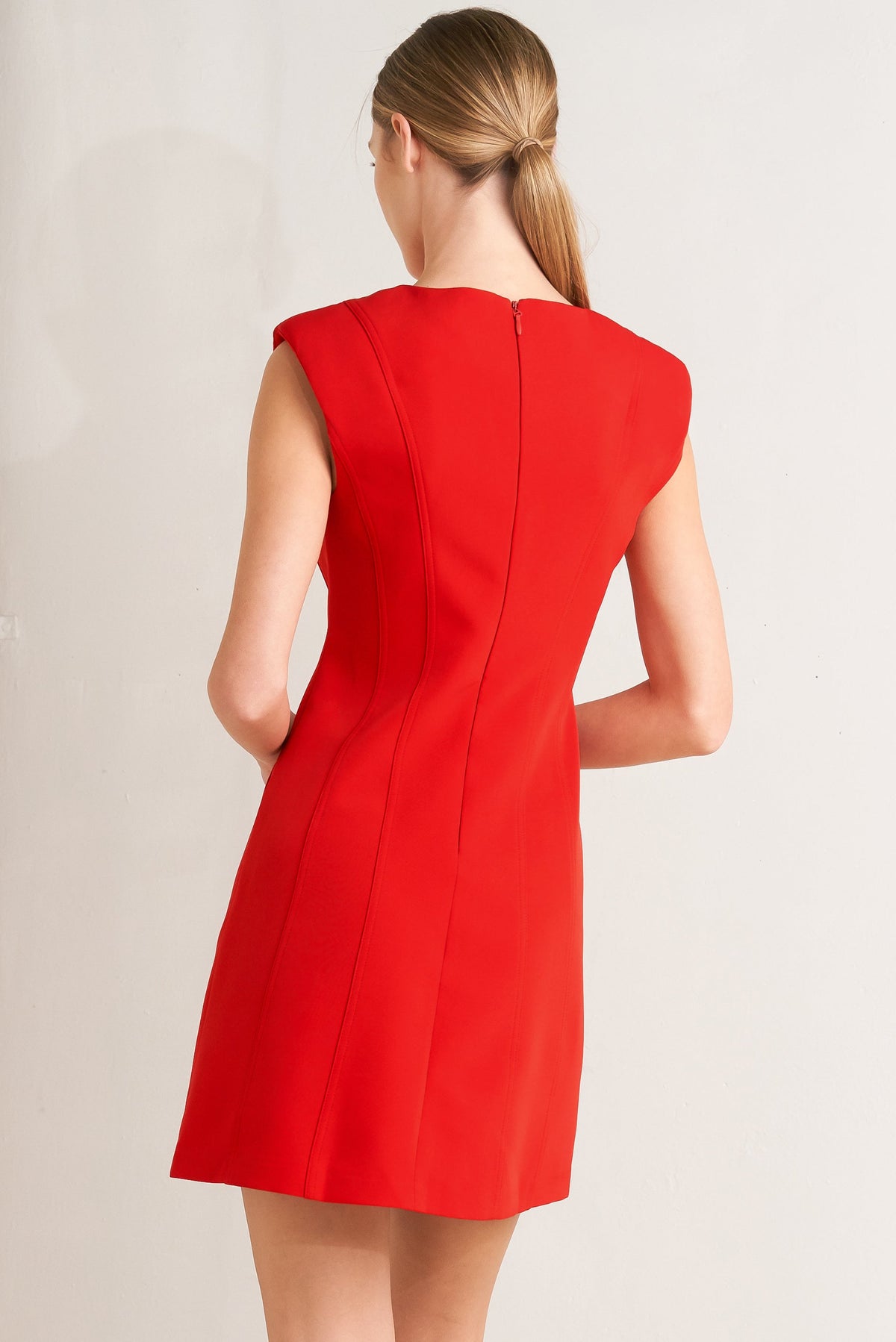 Red dress worn by a model on a plain background