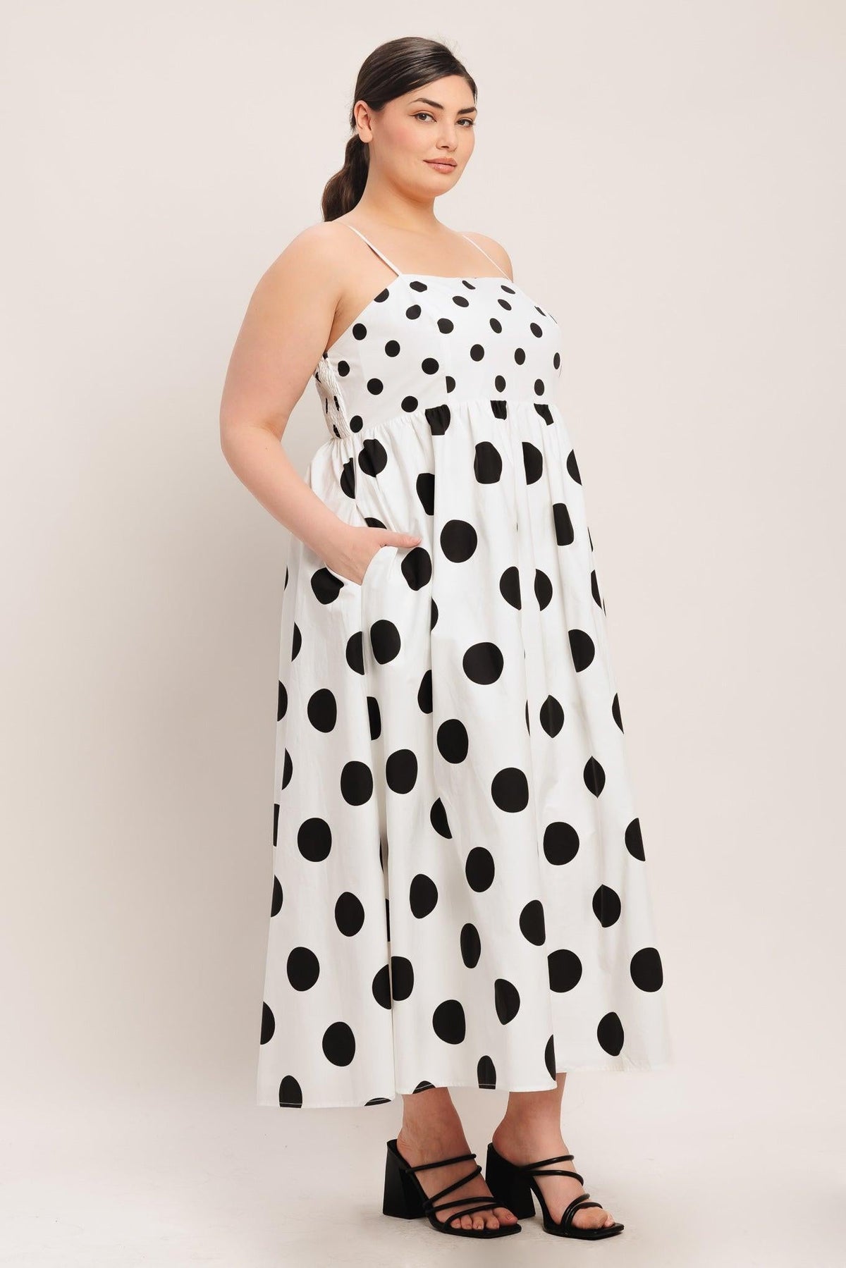 Woman wearing a polka dot dress on a plain background