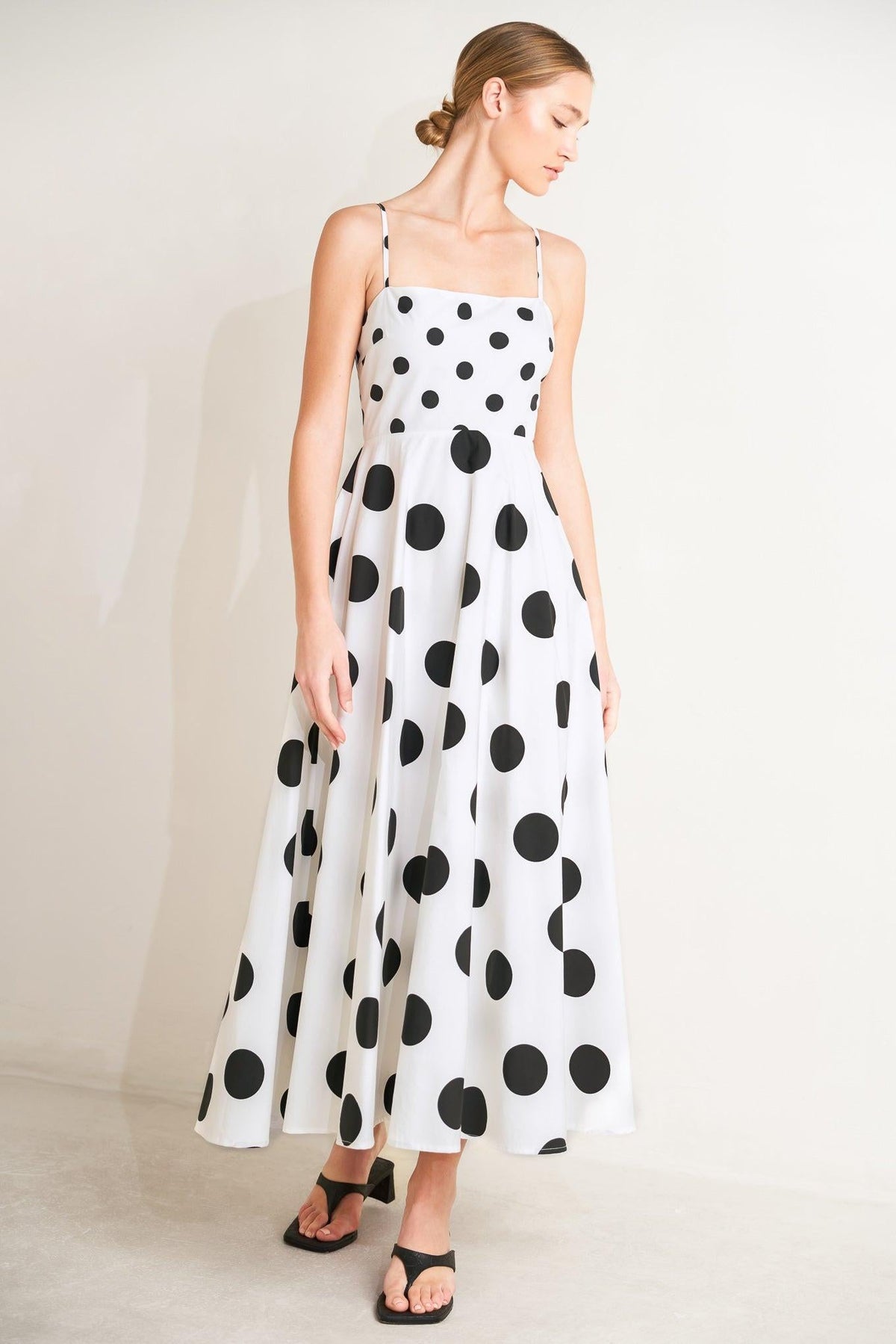 Woman wearing a polka dot dress on a plain background