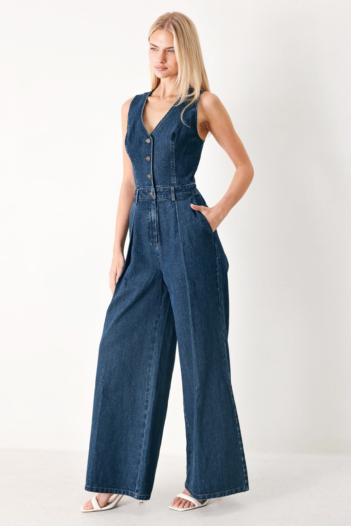Woman wearing a denim jumpsuit on a white background
