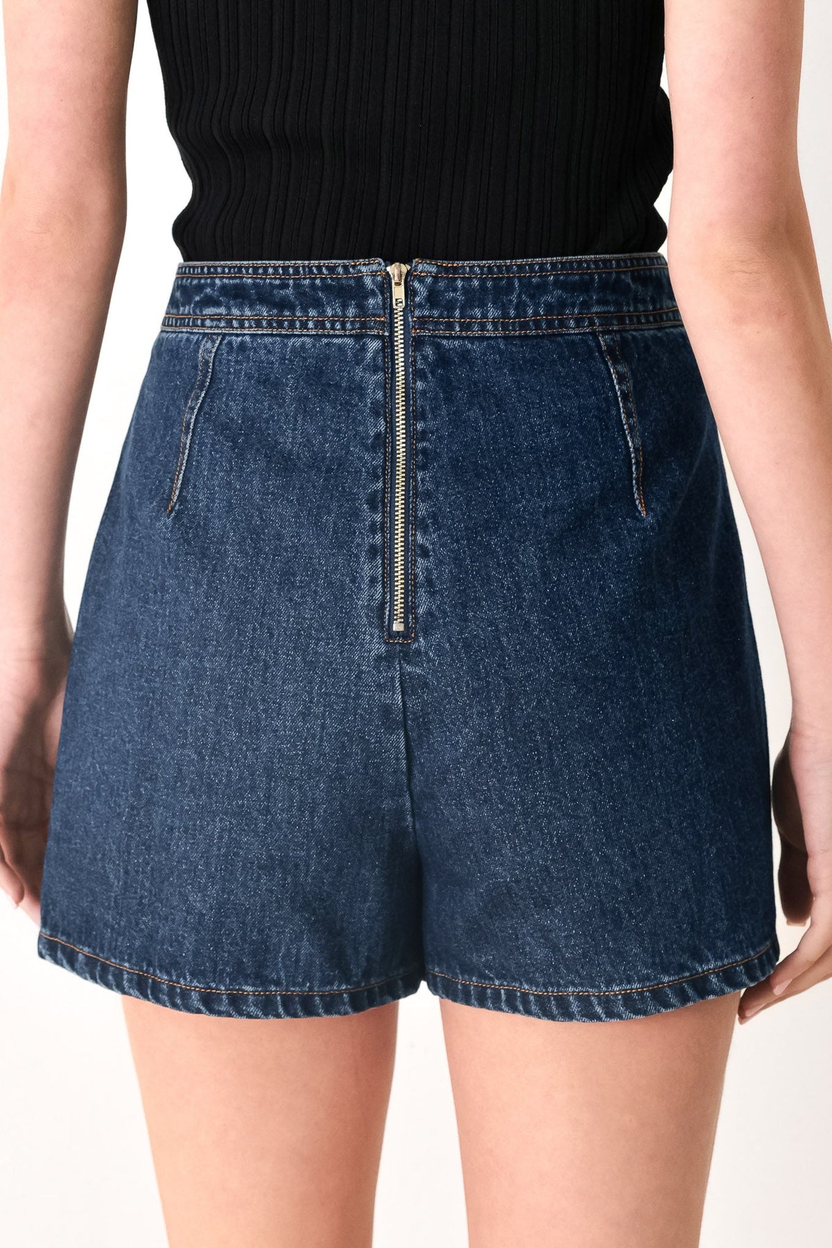 Blue denim shorts worn by a person on a white background