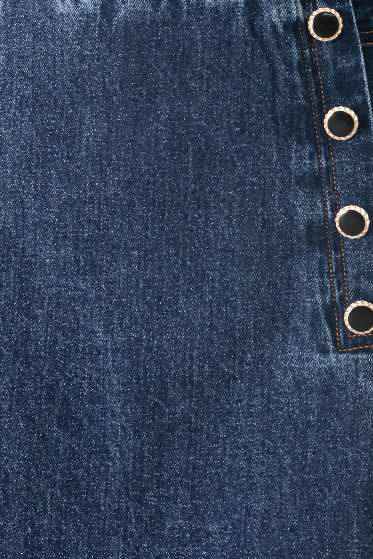 Close-up of blue denim fabric with button details
