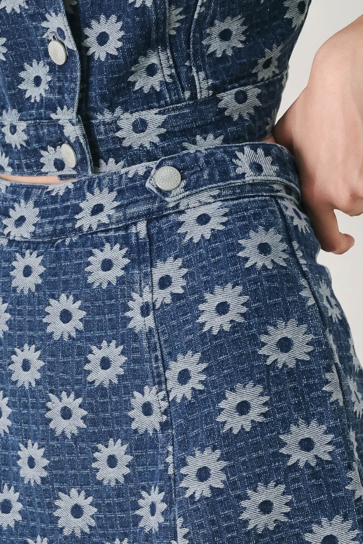 Close-up of a blue denim dress with white floral patterns