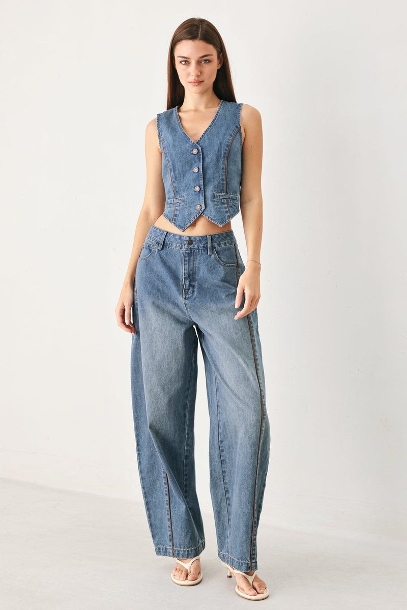 Woman wearing a denim vest and jeans on a white background