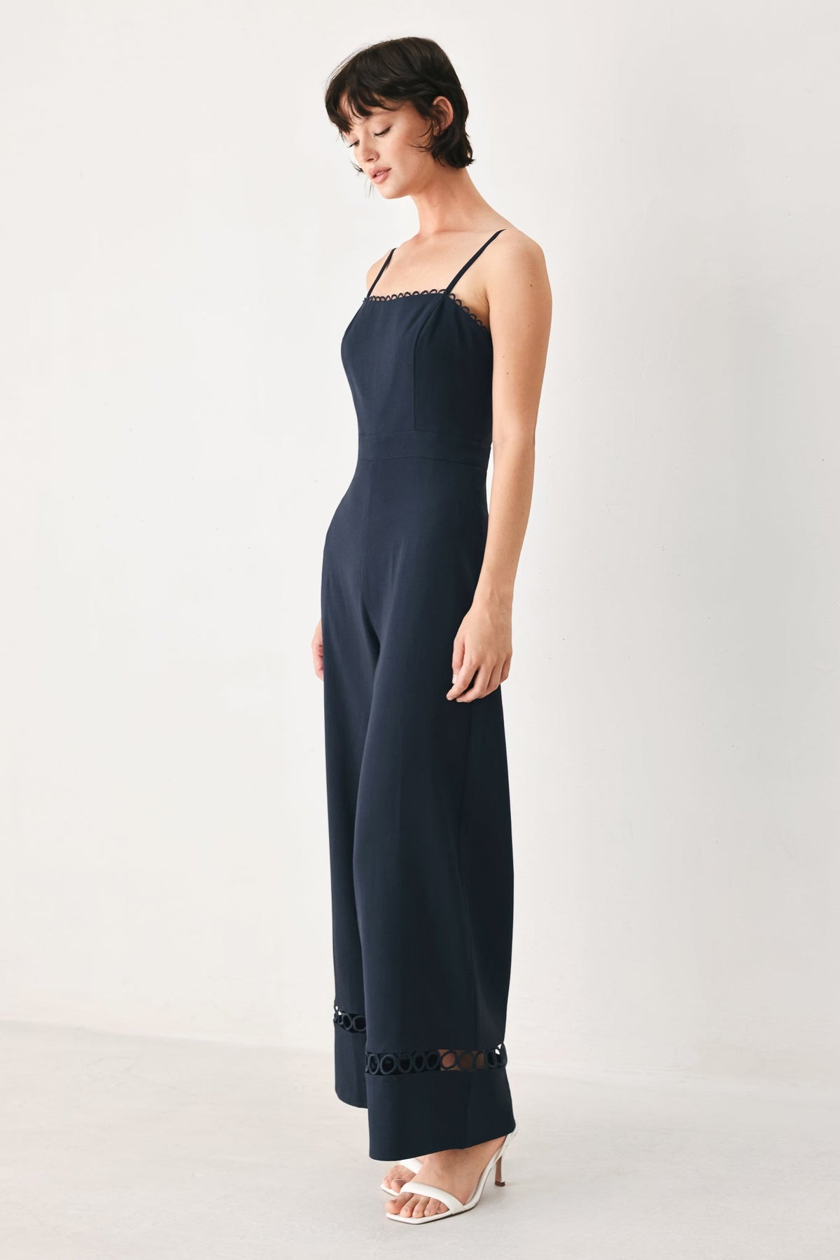 Woman wearing a black jumpsuit on a white background