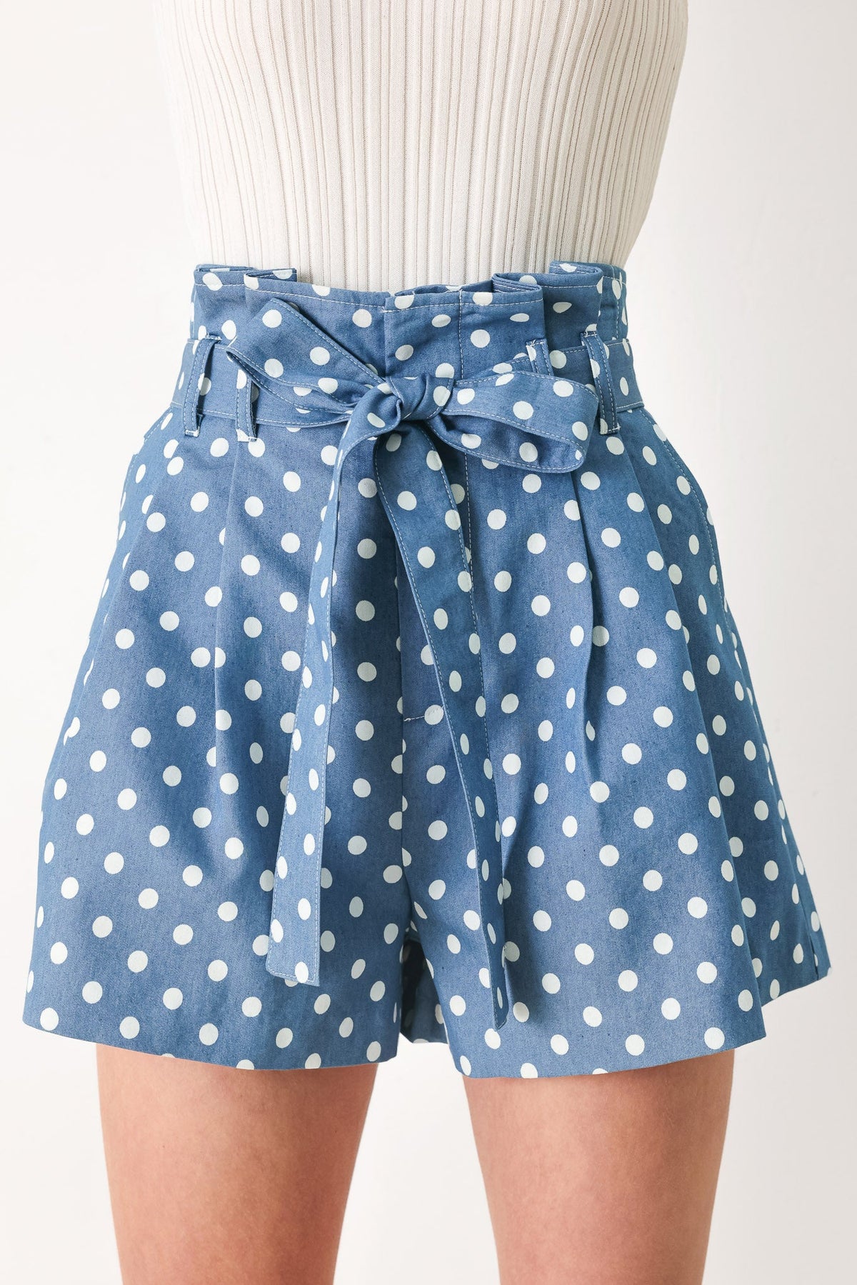 Blue polka dot shorts with a tie waist on a mannequin against a white background