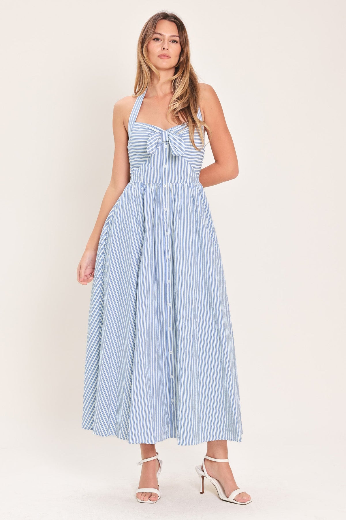 Woman wearing a blue and white striped dress on a white background