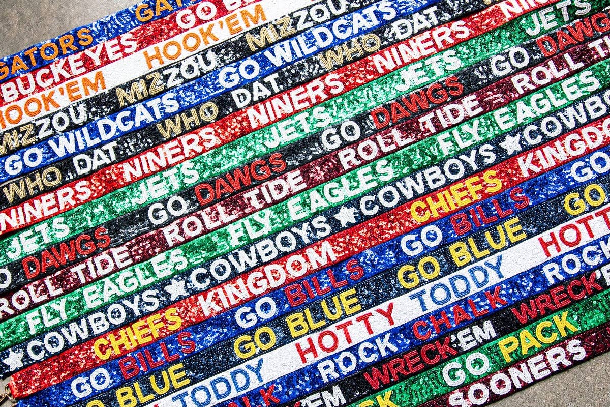 Collection of colorful woven belts with various text patterns.