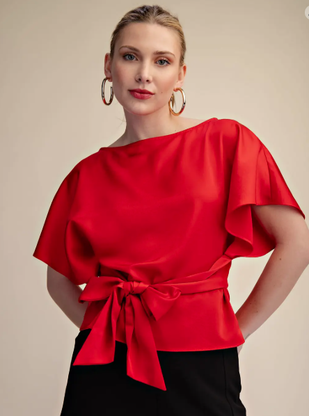 Woman wearing a red blouse with a beige background