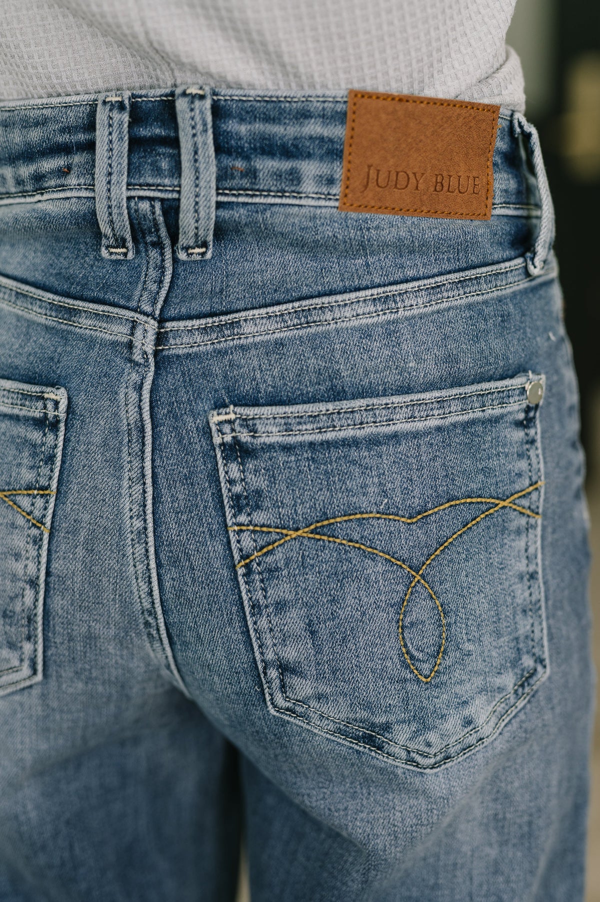 Close-up of blue jeans with a brand label on the back pocket.