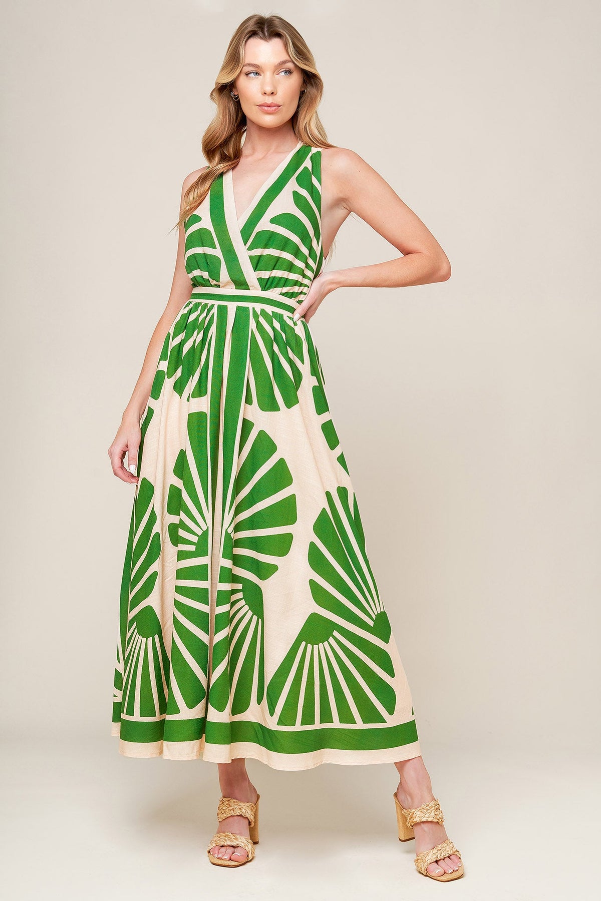Woman wearing a green and white patterned dress on a beige background