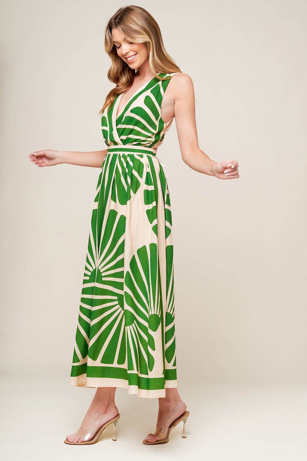Woman wearing a green and white patterned dress on a beige background