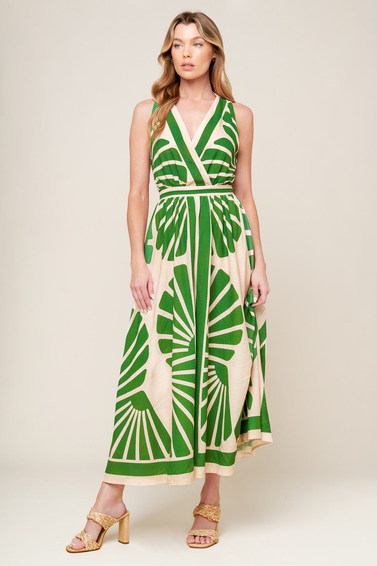 Woman wearing a green and beige patterned dress on a white background