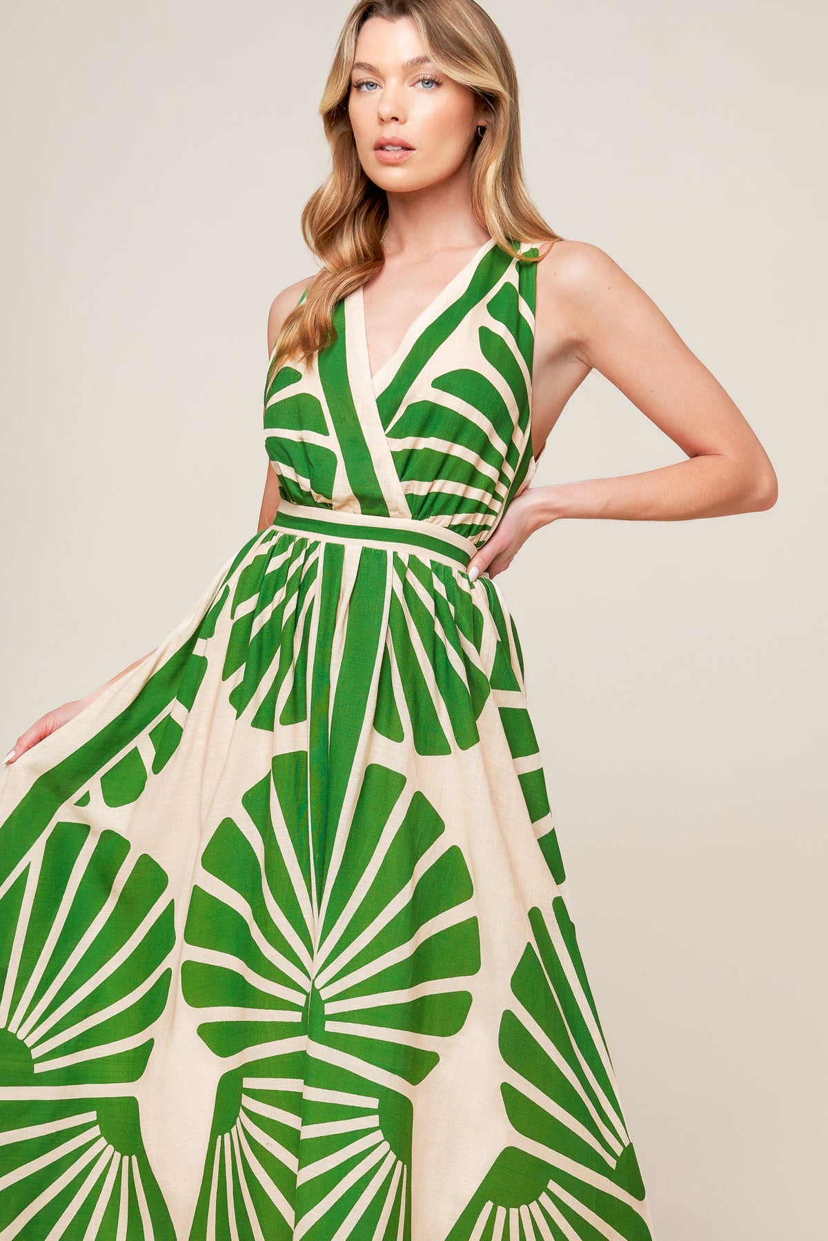 Woman wearing a green and white patterned dress on a beige background