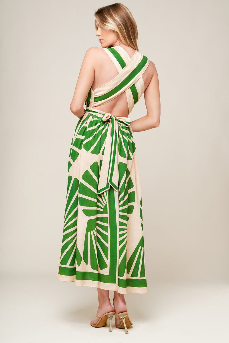 Woman wearing a green and white patterned dress on a plain background