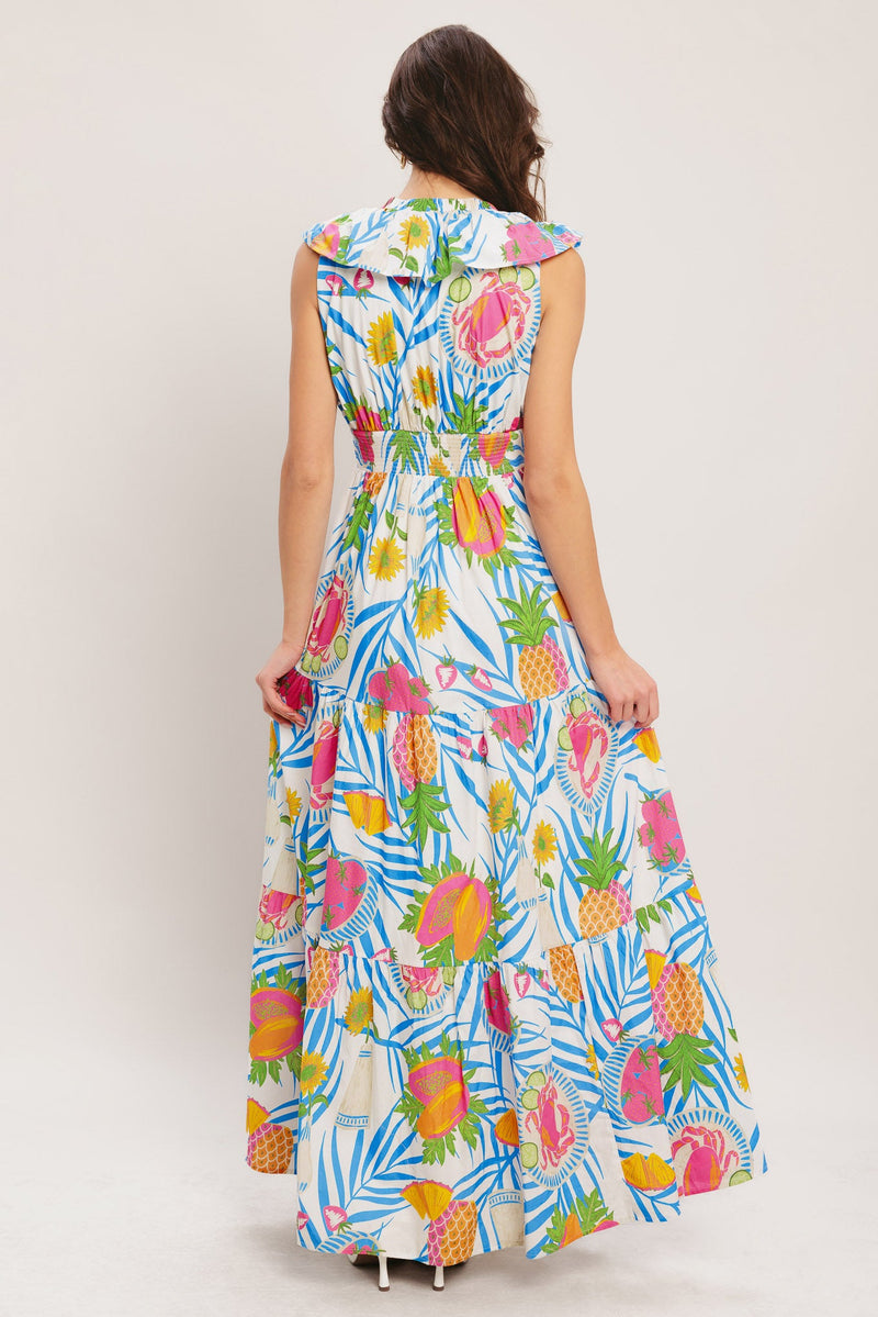 Woman wearing a colorful tropical patterned dress on a plain background