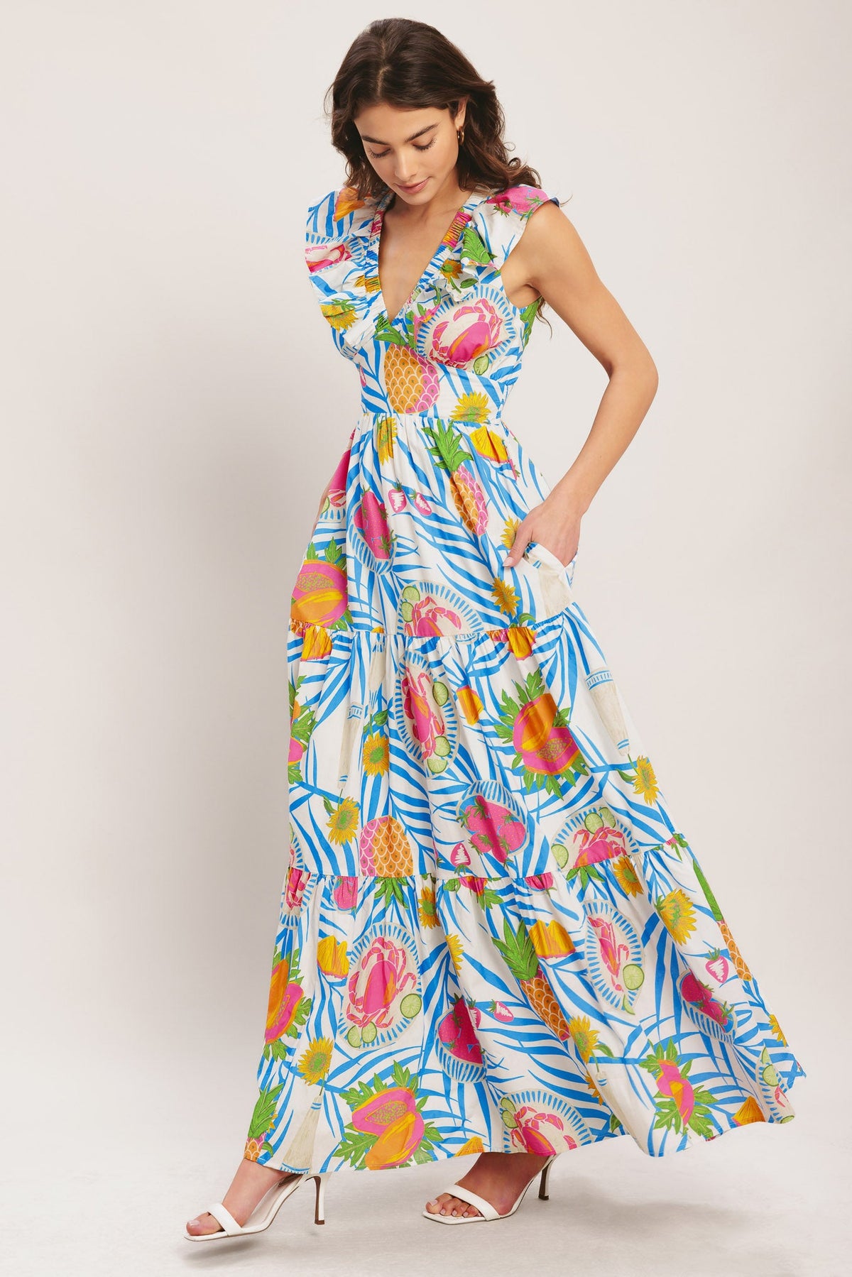 Woman wearing a colorful tropical patterned dress on a white background