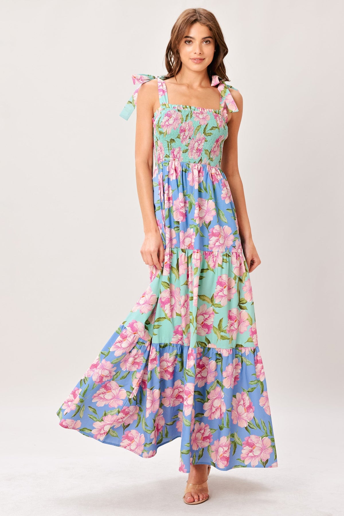Woman wearing a floral dress with pink and blue flowers on a white background