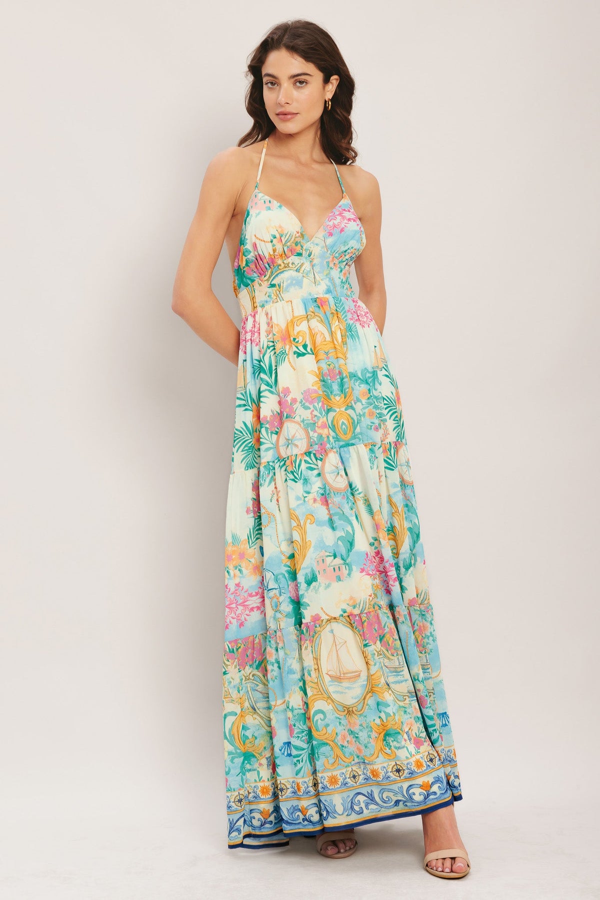 Woman wearing a colorful floral dress on a plain background