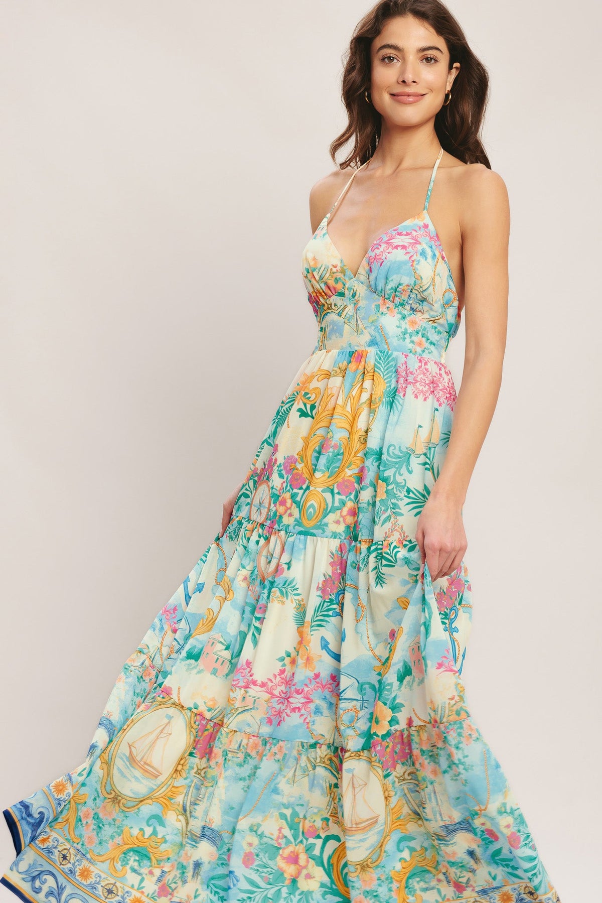 Woman wearing a colorful floral dress against a plain background