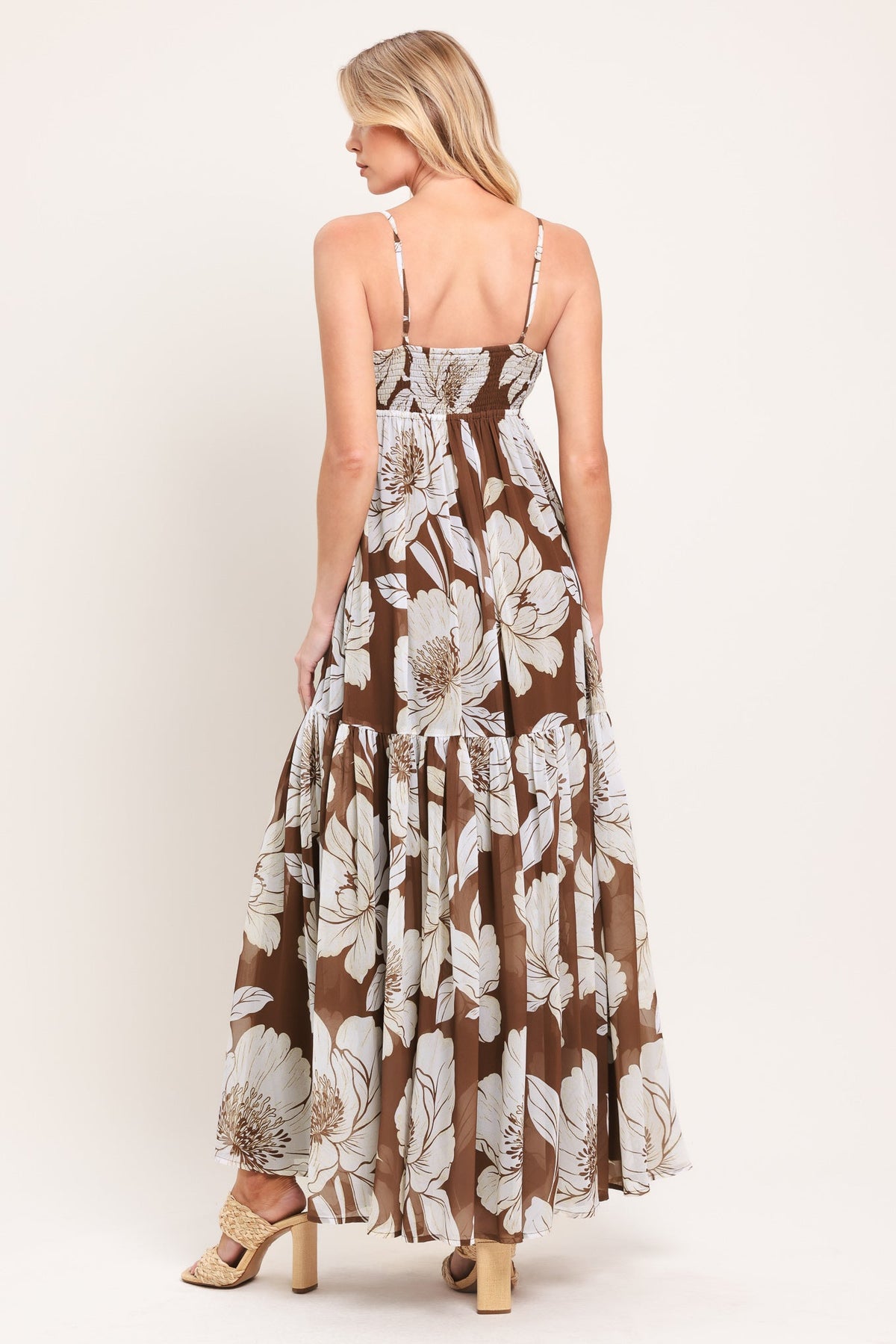 Woman wearing a floral maxi dress on a white background