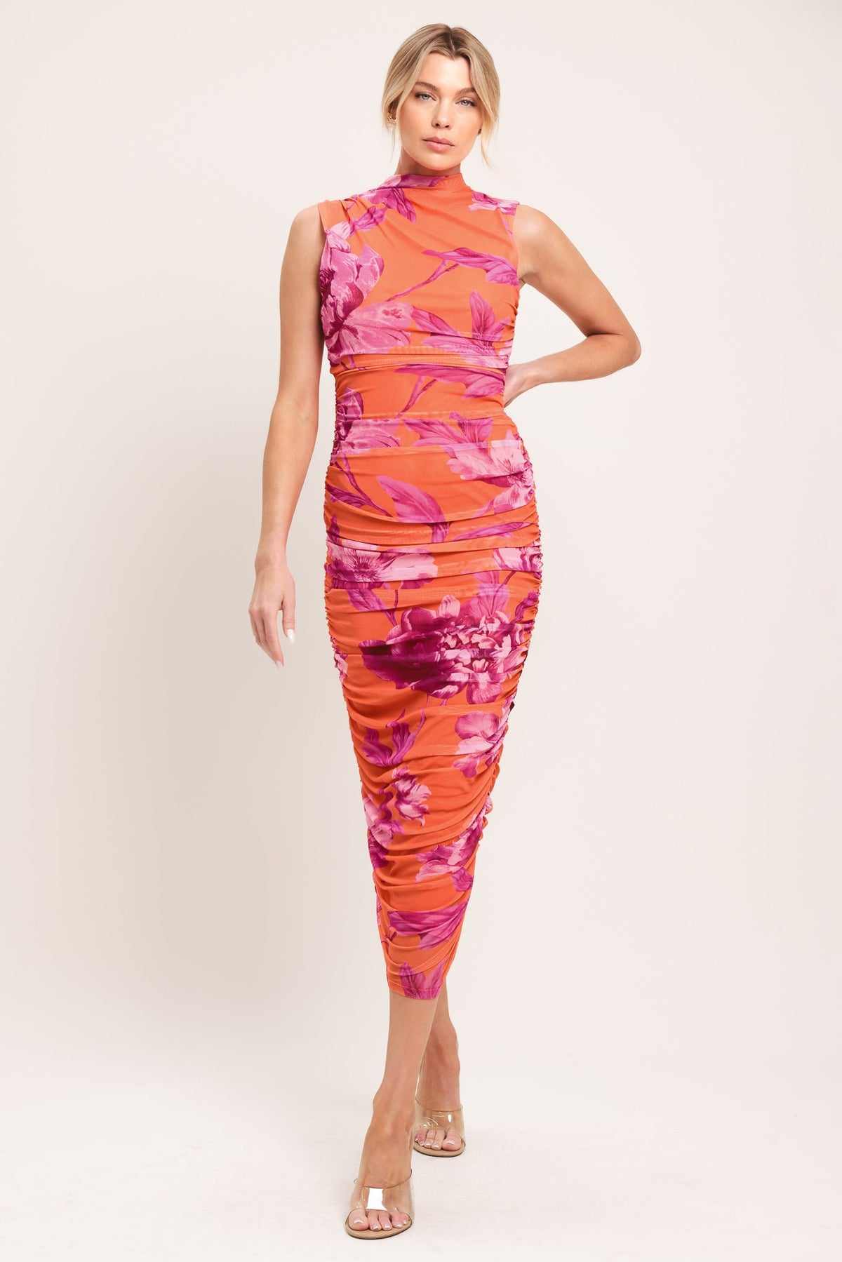 model in orange and pink dress on white background
