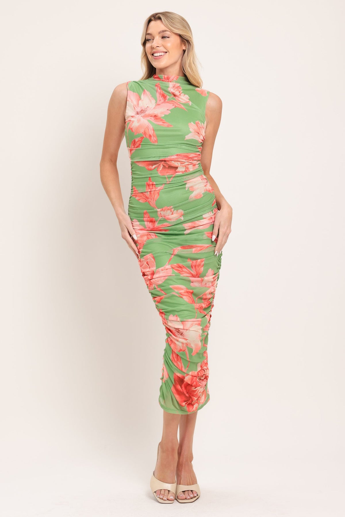 model in green and pink dress on white background