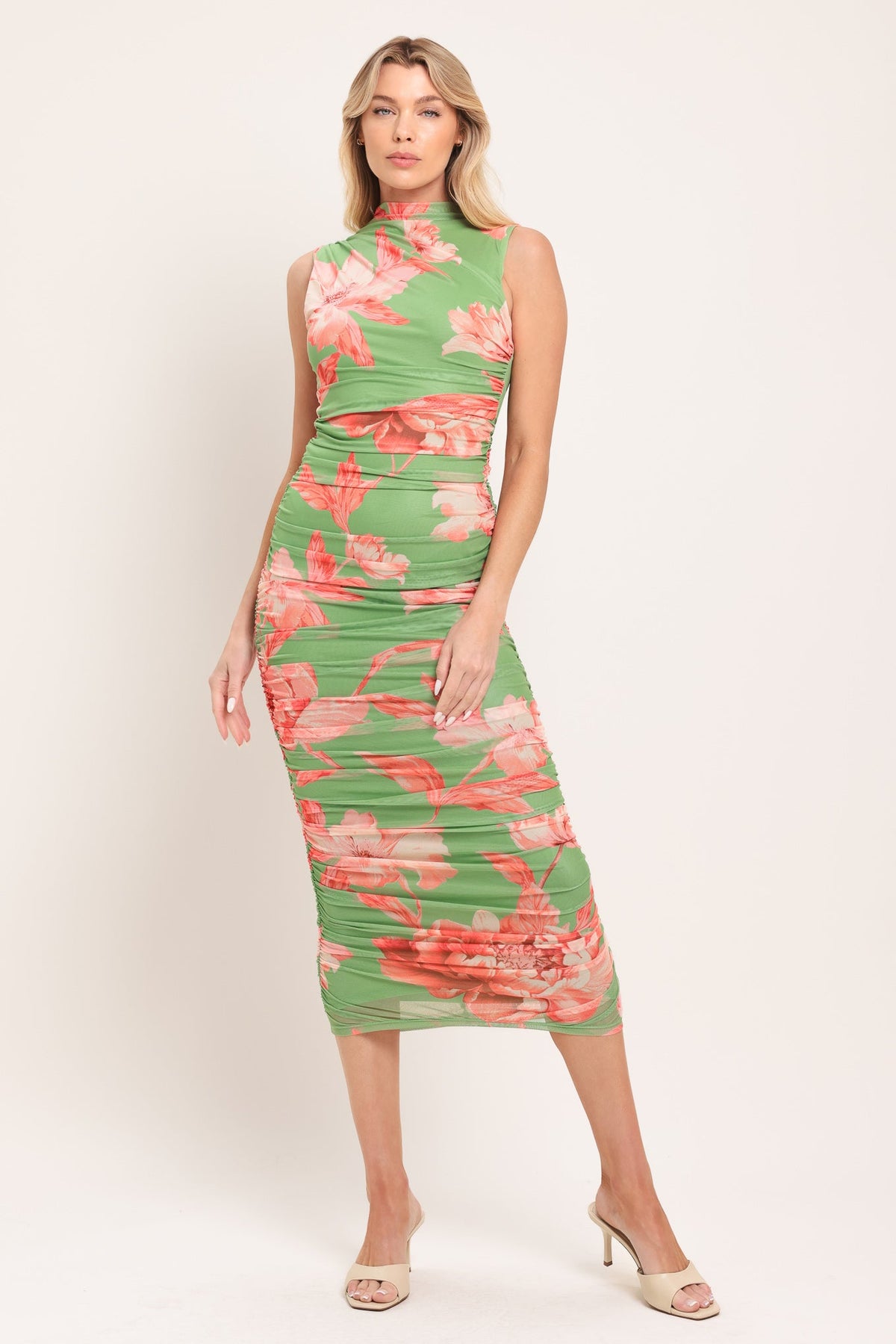 Woman wearing a green floral dress against a white background
