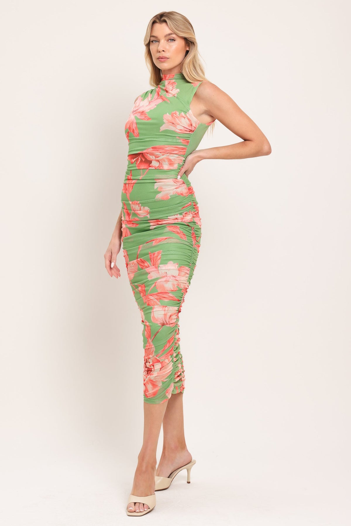 model in green and pink dress on white background