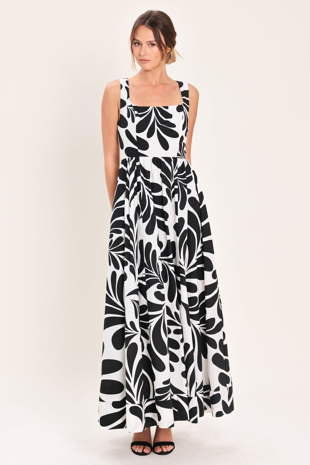 Woman wearing a black and white patterned dress on a white background