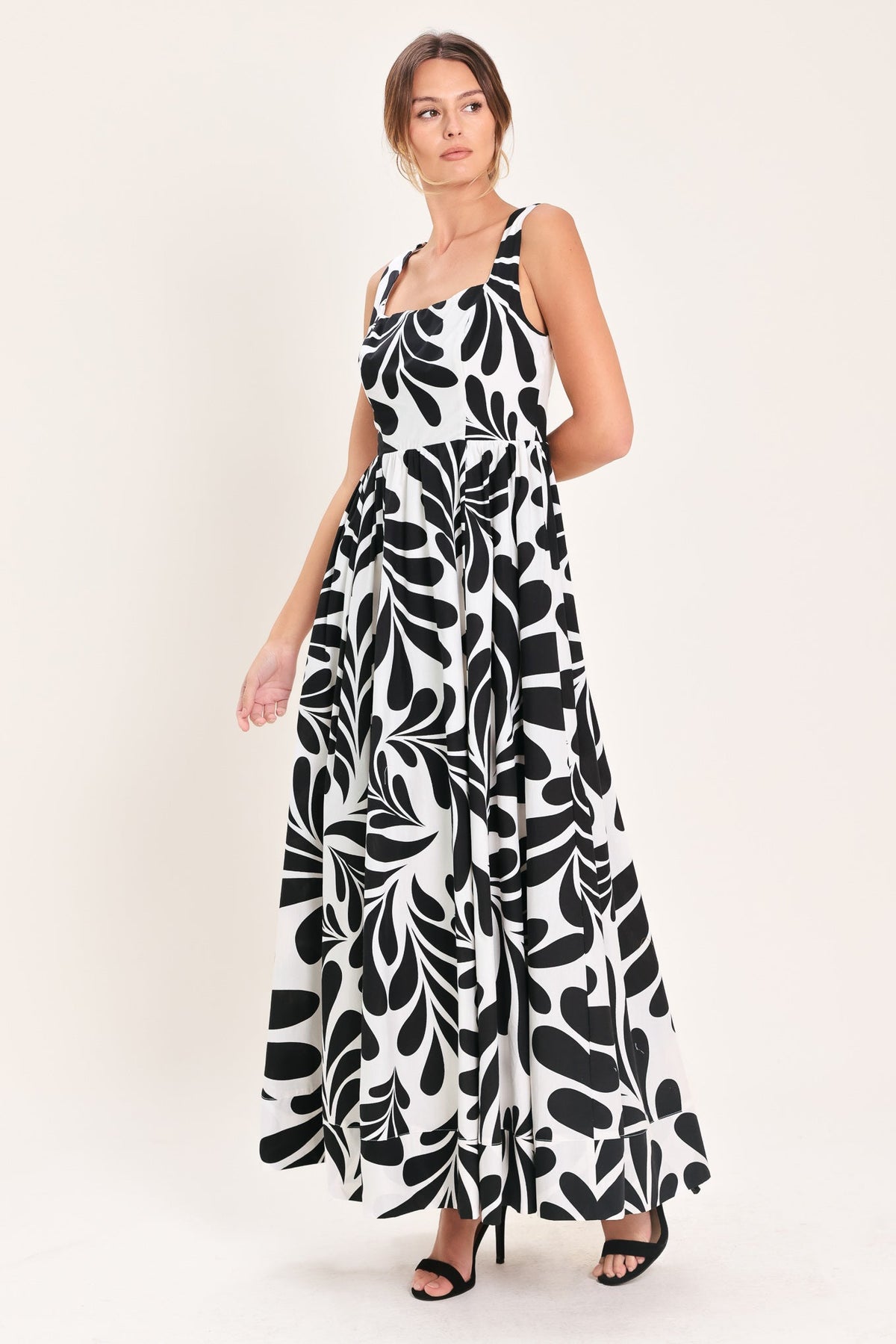 Woman wearing a black and white patterned dress on a white background