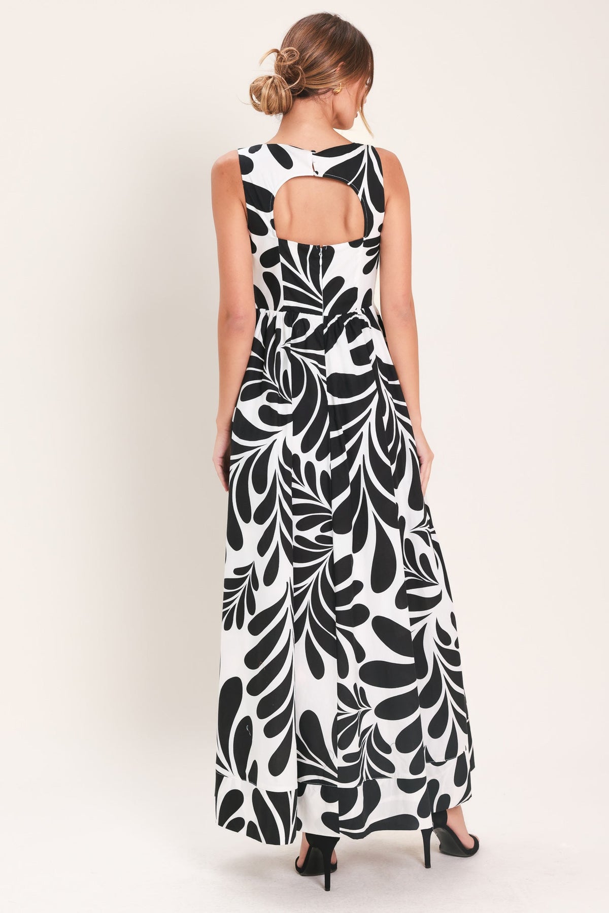 Woman wearing a black and white patterned dress on a white background