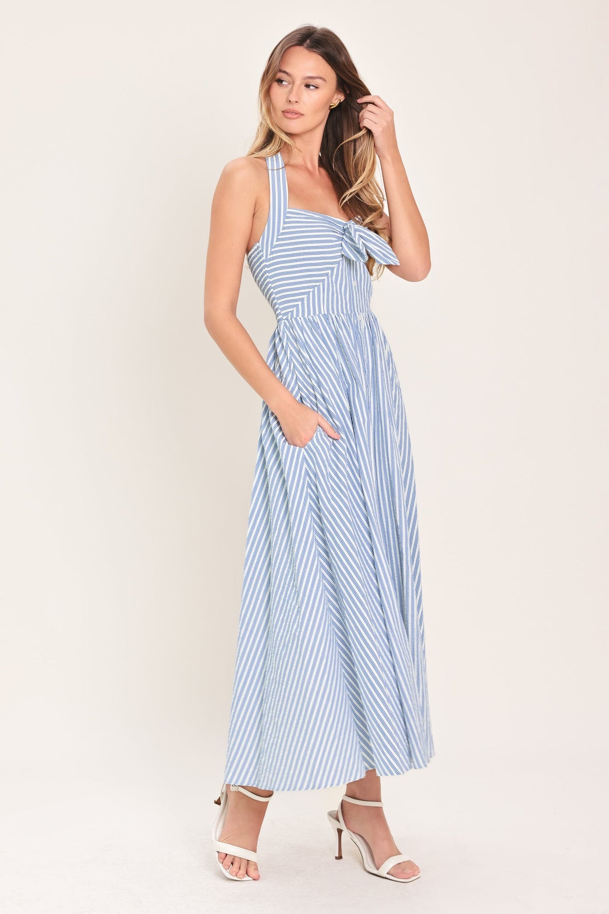 Woman wearing a blue and white striped dress on a light background