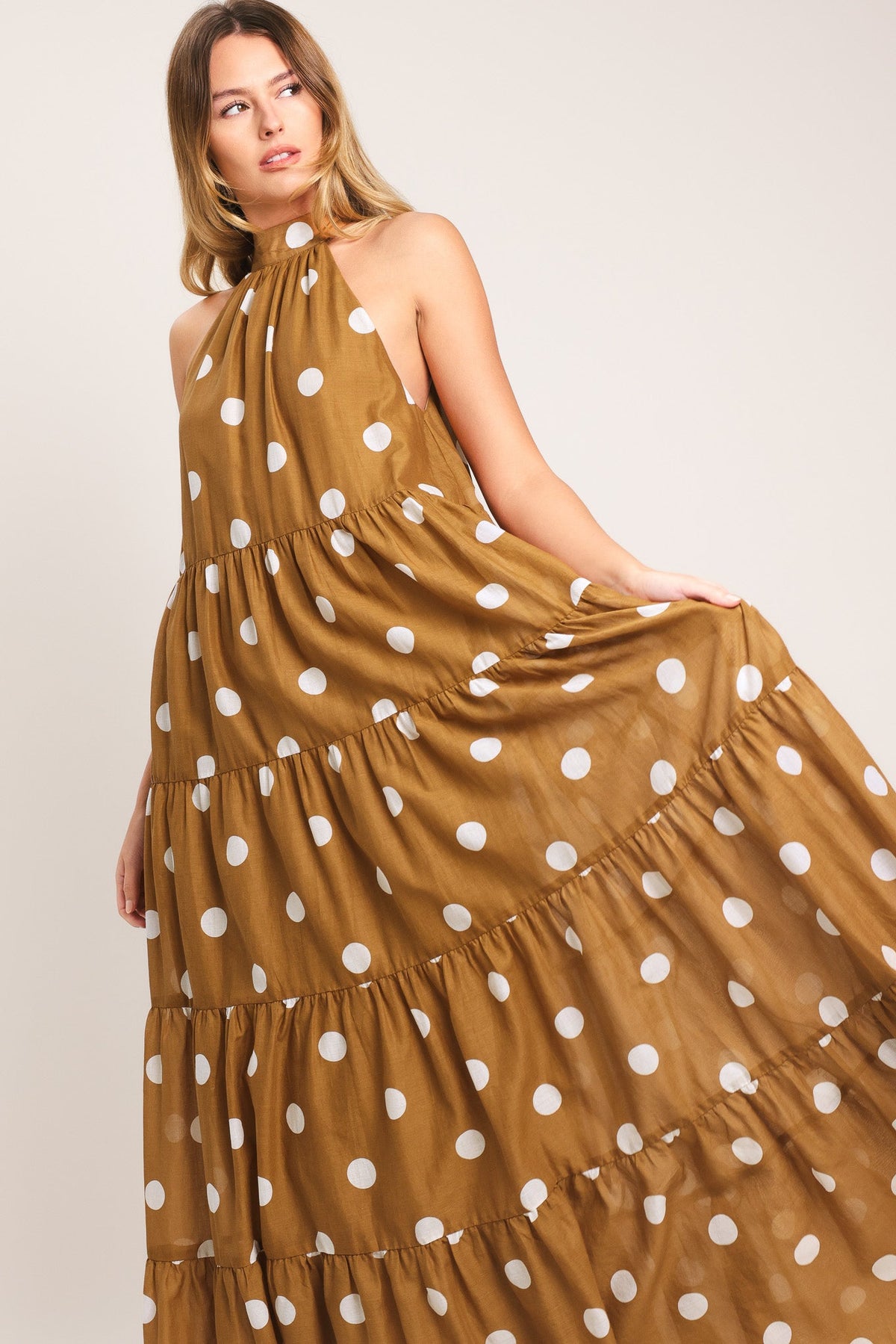 Woman wearing a polka dot dress with a plain background