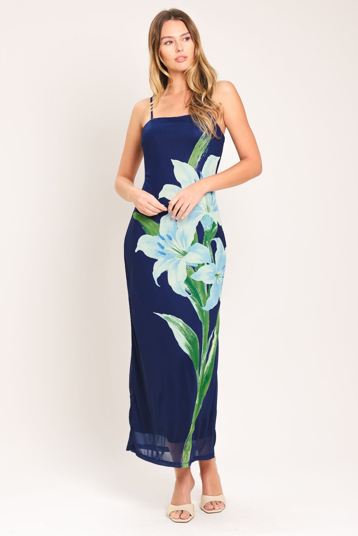 Woman wearing a navy dress with floral design on a white background