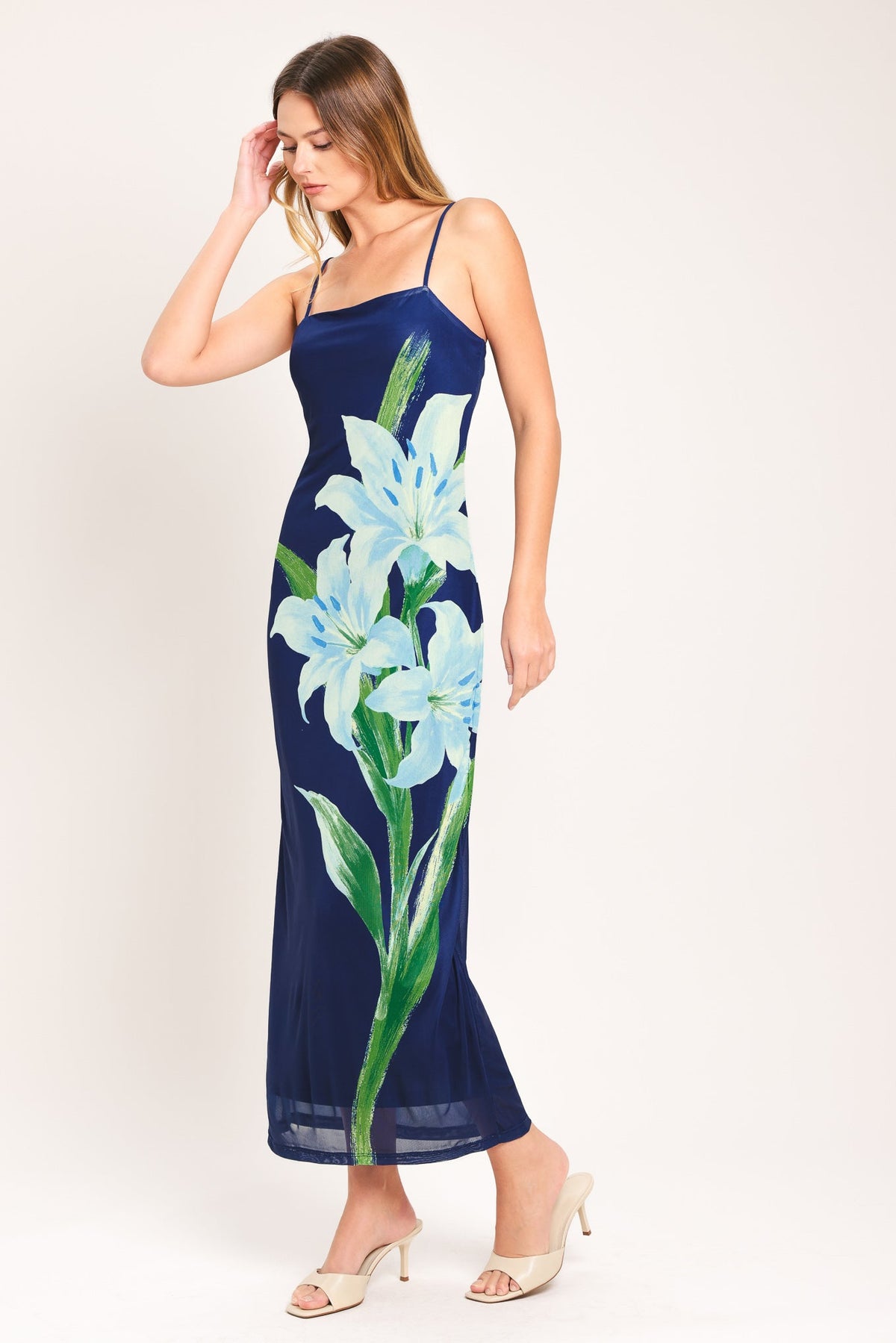 Woman wearing a navy blue dress with floral design on a white background