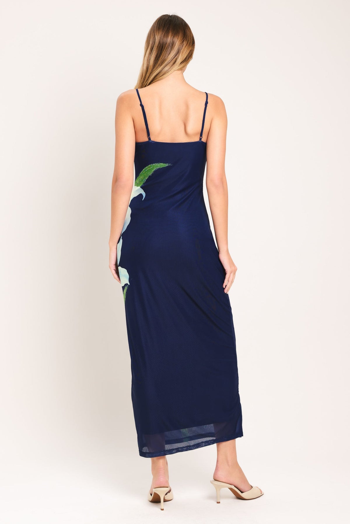 Woman wearing a navy blue dress with a parrot design on a white background