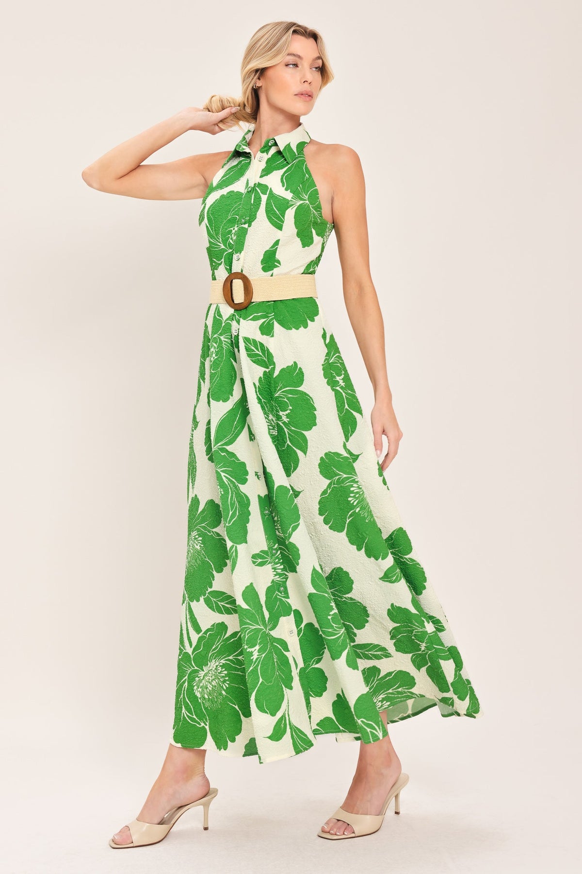 Woman wearing a green leaf-patterned dress on a white background